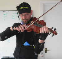 Using an Animazoo motion capture system and vibrotactile feedback to train novice violin players. Photo by Jon Bird.